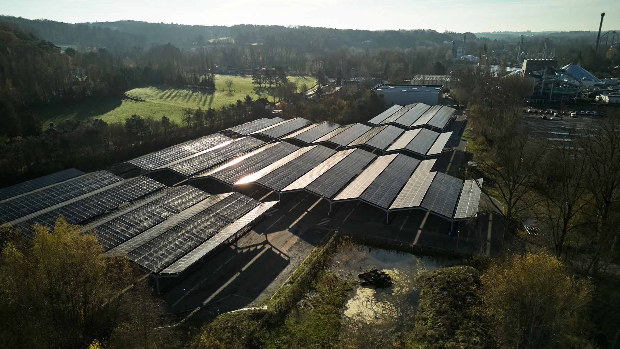 Aerial view of a large solar farm featuring numerous solar panels arranged in rows under a clear blue sky.