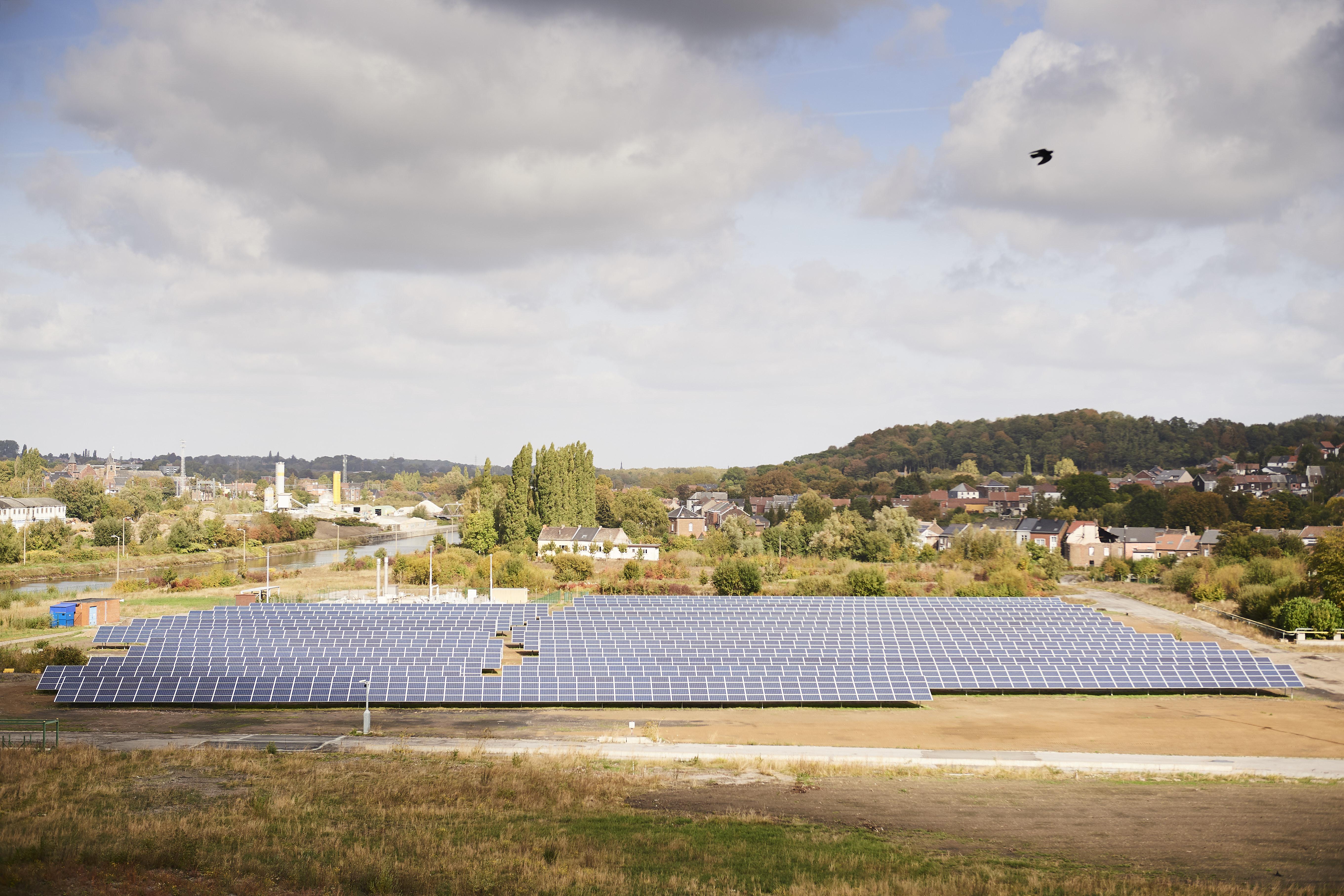 Solar farm installations in a field near a village